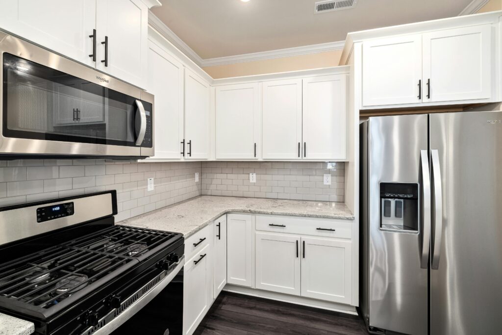Stylish modern kitchen featuring white cabinets and stainless steel appliances.