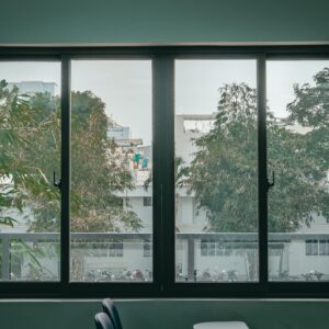 Serene view through a large window of an urban classroom, featuring trees and cityscape.