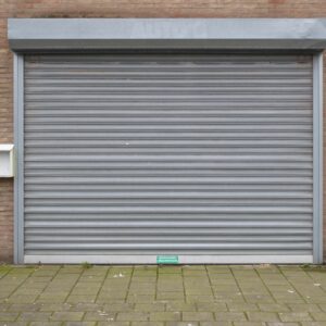 Closed grey metal roller shutter door for security and protection in urban exterior.