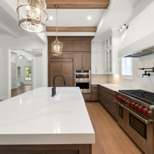 Elegant modern kitchen featuring marble countertops, stainless steel appliances, and hardwood floors.